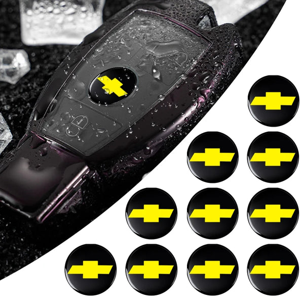 A set of black key emblem stickers with yellow lightning bolt designs on a dark surface.