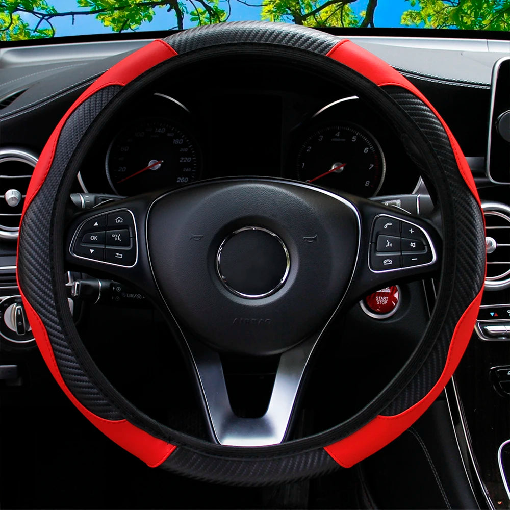 A close-up view of a black steering wheel with red accents and carbon fiber trim inside a car