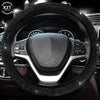 A close-up view of a black steering wheel covered in sparkling crystal rhinestones.