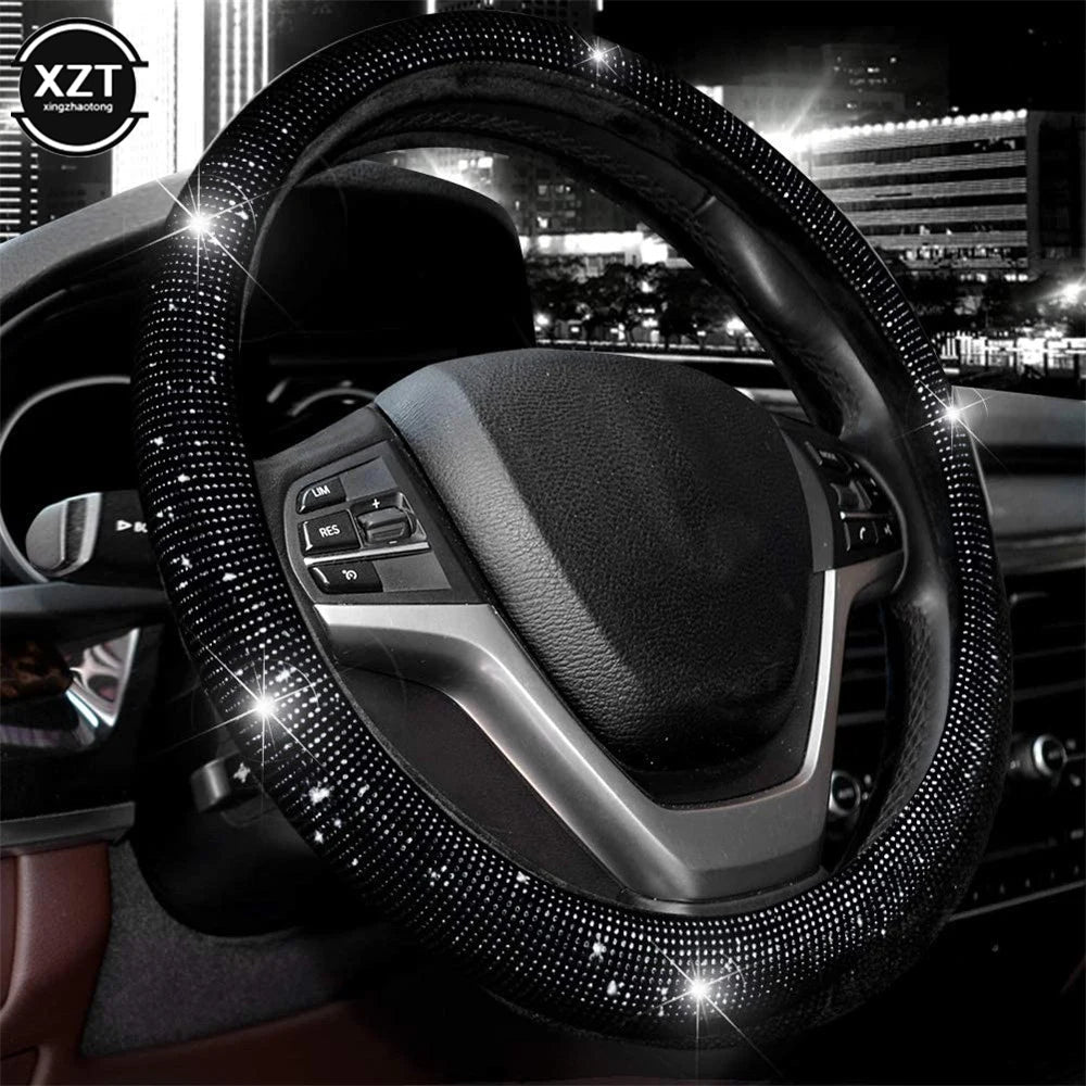 A close-up view of a black steering wheel covered in sparkling crystal rhinestones.