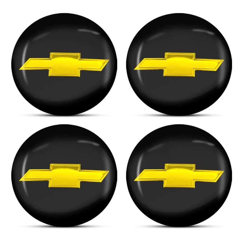 Four glossy black decorative car wheel hub center caps with gold accents