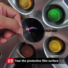 A hand is shown tearing a protective film from a black center cap decal for a car wheel hub.