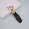 Gold-toned TPU car key fob cover with a leather strap and a signature initial on the back