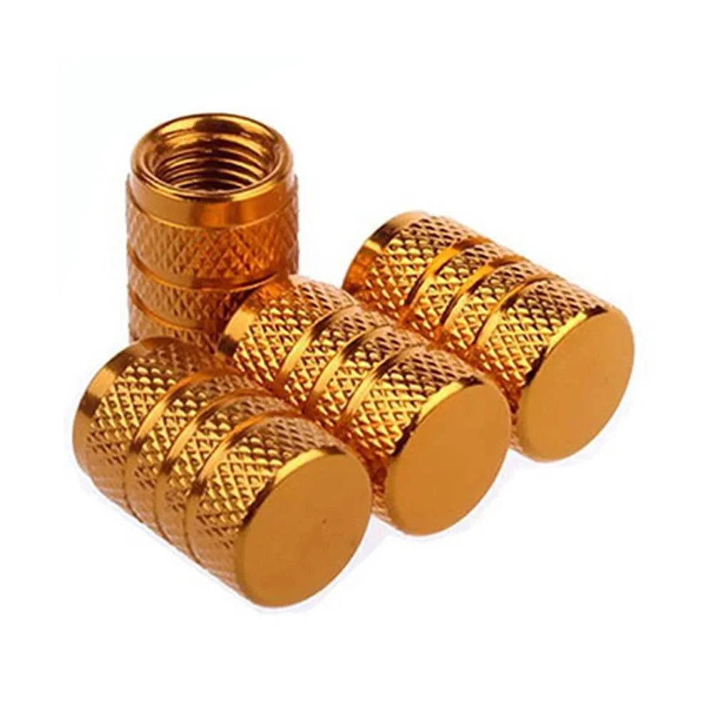 A set of brass or gold-colored aluminum tire valve caps, showing various sizes and threading.