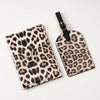A black and beige leopard print passport holder with card slots attached to a black strap.