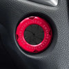 A close-up of a red decorative ignition cover with START/STOP markings on a black surface.
