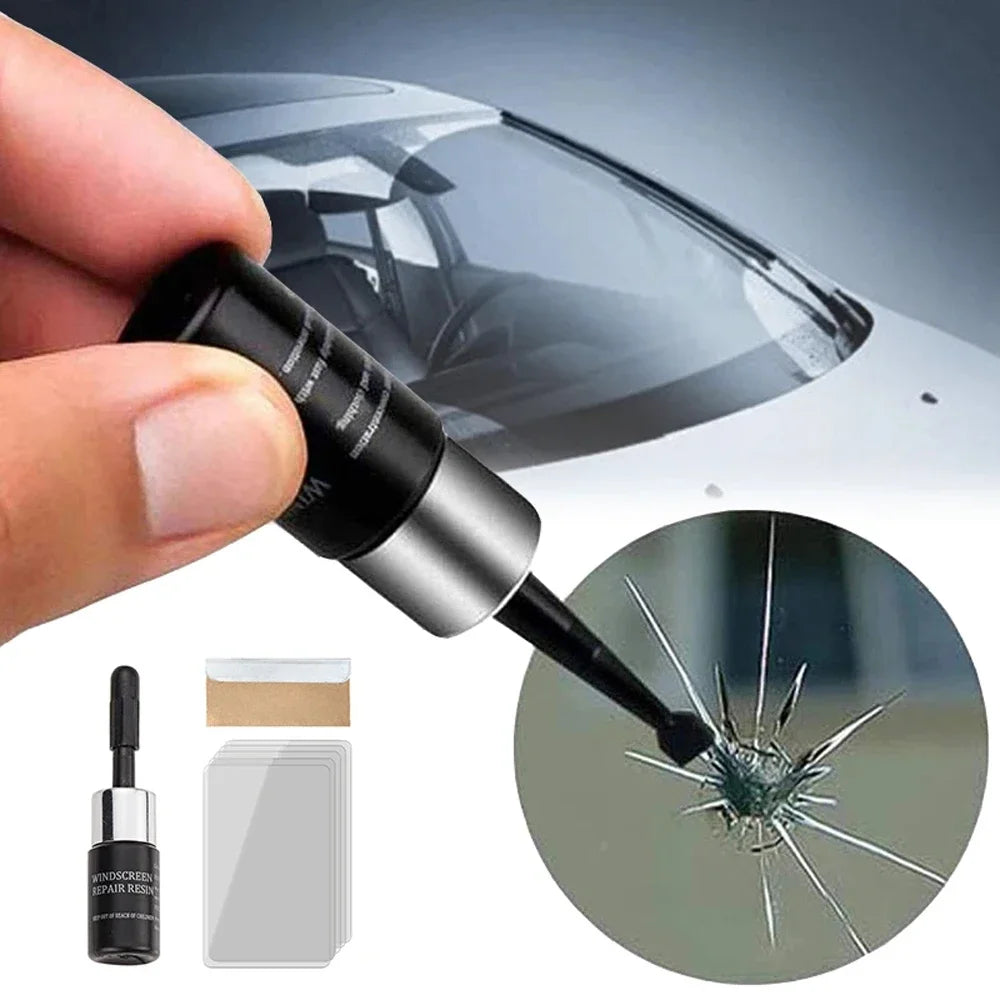 A hand holds a black tool used to repair car windshield cracks, showing the needle tip applying adhesive to the glass.