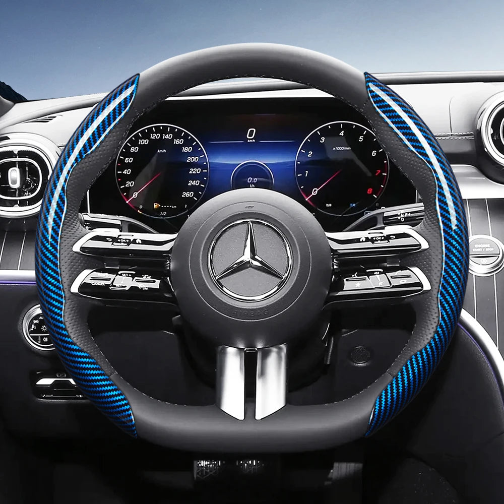 Close-up view of a black steering wheel with blue carbon fiber texture accents and a Mercedes-Benz instrument cluster.