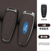 A pair of Ford car key covers in brown leather and silver metal, with a remote control shown separately.
