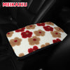 A plush car armrest cushion featuring a pattern of pink, red, and brown floral shapes.