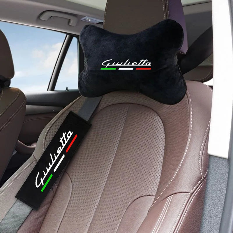 A black shoulder cushion with the name Giulietta embroidered in green and red on a beige car seat.