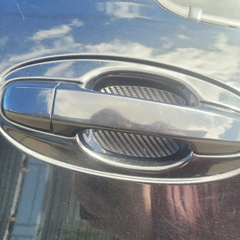Close-up of a car door handle with a clear protective film applied to the grip area.