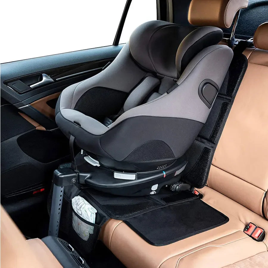 A car seat protector pad is installed in the back seat of a vehicle, visible on the leather upholstery.