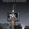A handheld industrial endoscopic camera with a black body and orange tip is shown against a dark, rocky background.