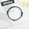 A dark green heart-shaped fitness tracker bracelet is shown on a white background next to a black sign labeled White.