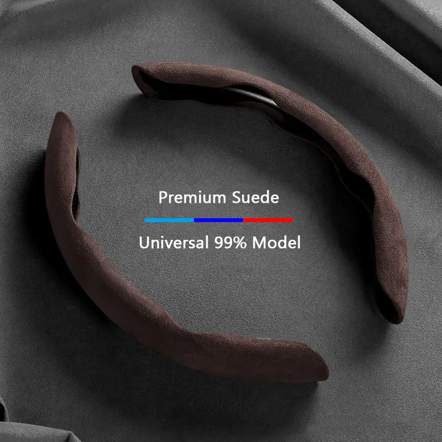 A dark brown suede steering wheel cover is shown on a gray surface, labeled as a universal 99% model.