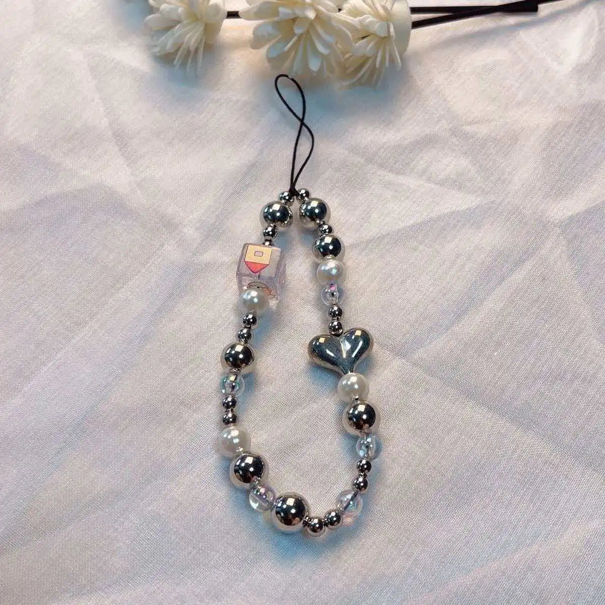 A silver and clear bead lanyard with a heart pendant is displayed against a white background.