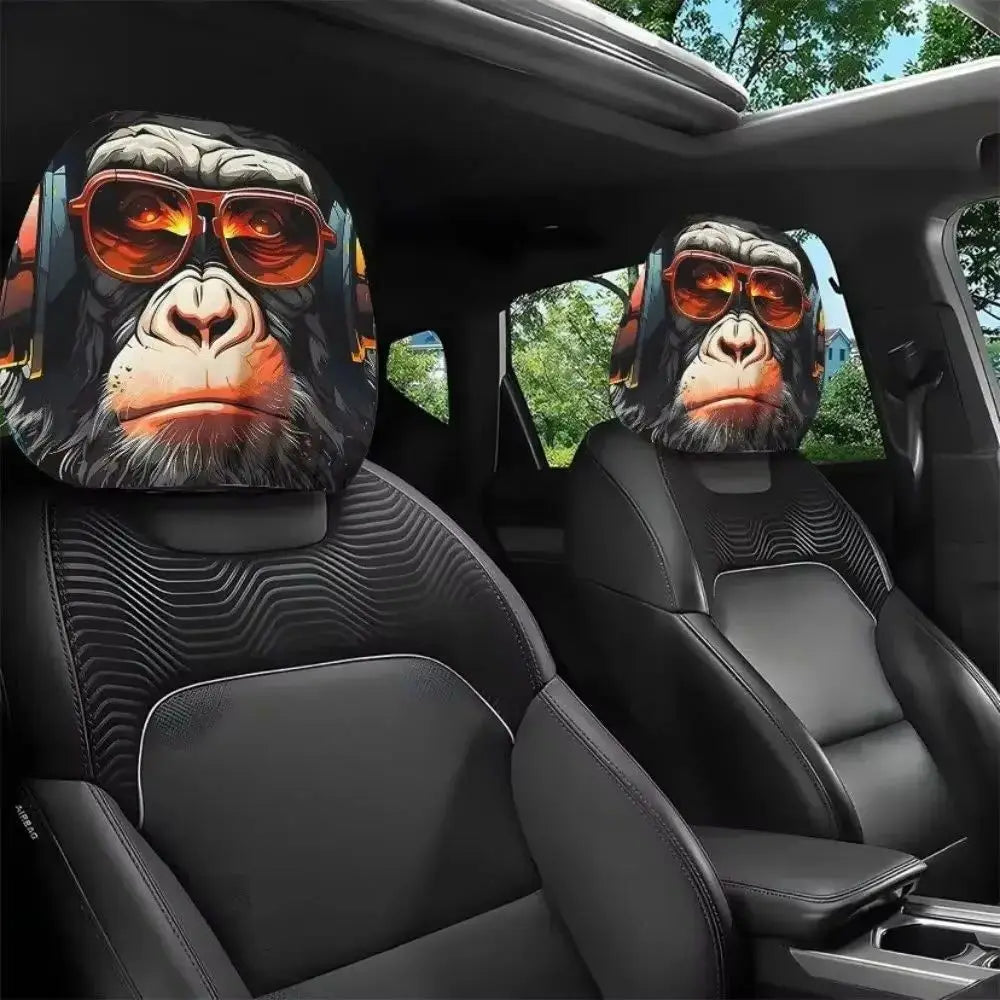 Two black gorilla headrest covers with orange sunglasses are shown inside a car seat.