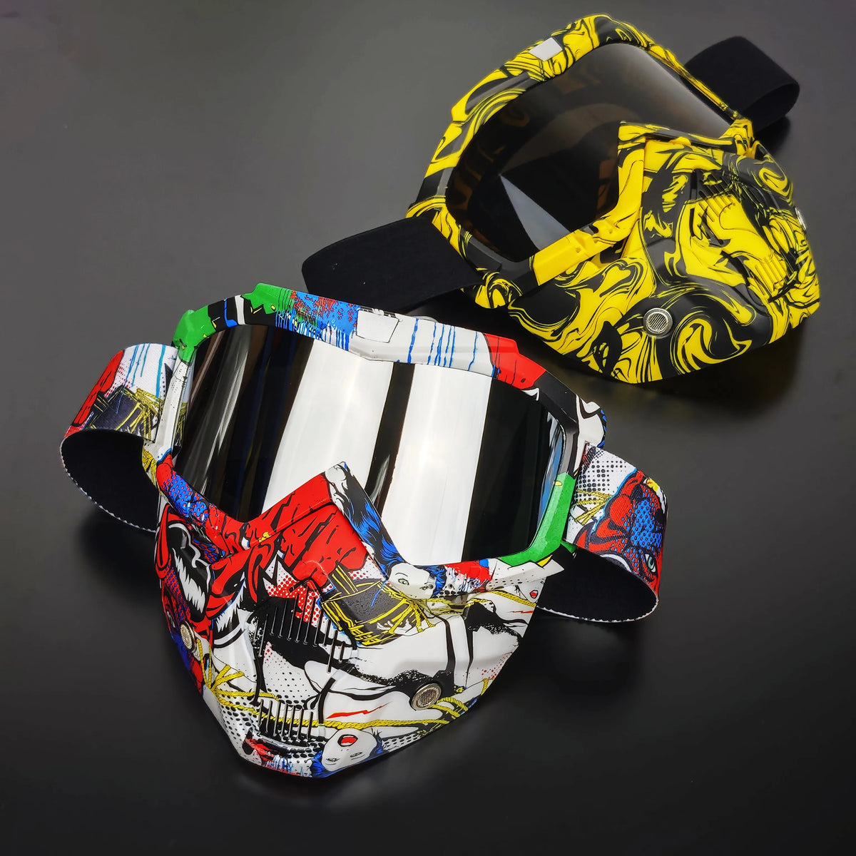 A pair of tactical full face motorcycle goggles with colored lenses, featuring a yellow and black pattern and a white and str