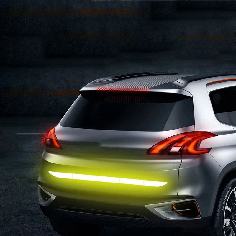 Vorderansicht eines silbernen SUVs mit reflektierenden Sicherheitsstreifen auf der Motorhaube und Tagfahrlicht.