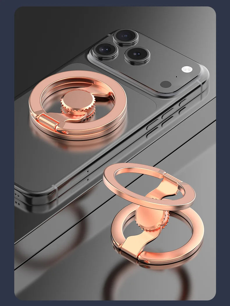 A close-up of a rose gold magnetic phone ring stand with a dual-sided grip resting on a smartphone.
