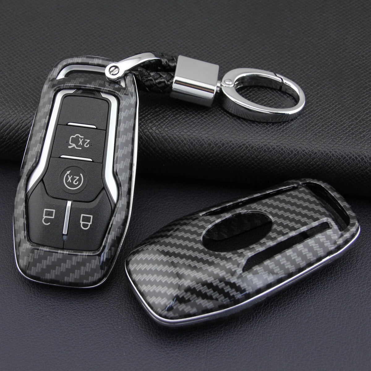 A carbon fiber style key fob cover with a metal chain is shown against a dark background.