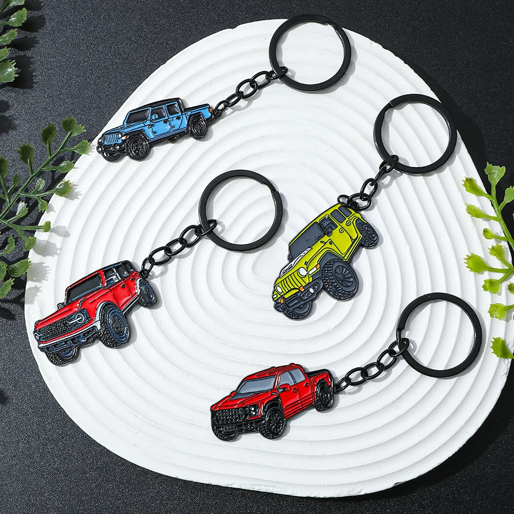 Four classic alloy car keychains in red, blue, yellow, and black are displayed on a white plate.