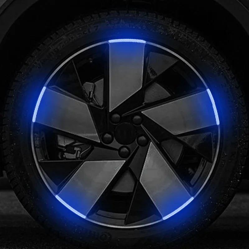 Gros plan sur une roue de voiture ou de moto avec un éclairage LED bleu illuminant le design des rayons.
