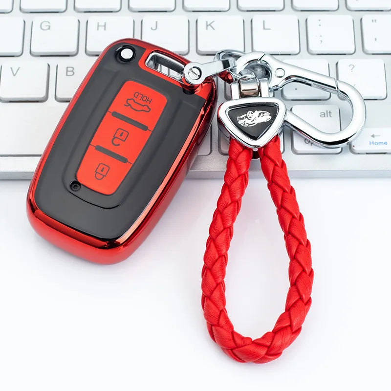 A red universal car key case with a lanyard attached, resting on a white keyboard.