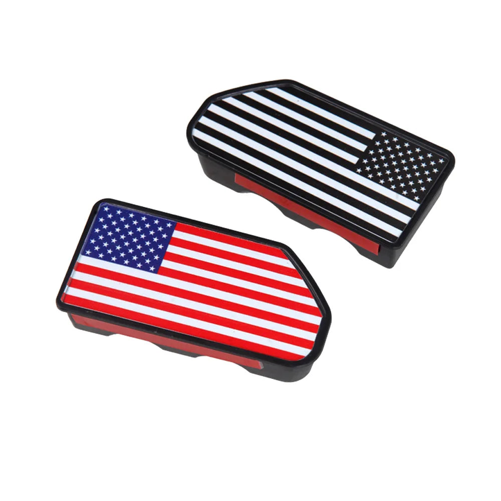 A pair of black truck bed rail hole plugs featuring the American flag design.