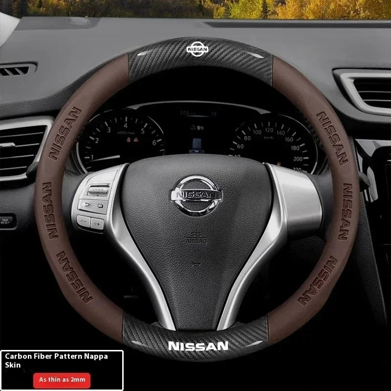 Close-up of a Nissan steering wheel with a carbon fiber patterned leather cover.