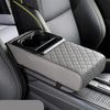 A gray quilted car armrest cushion with an integrated cup holder is shown in a vehicle interior.