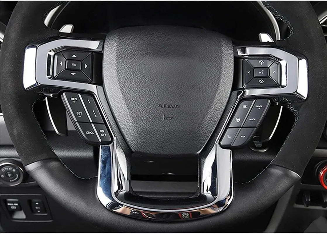 Close-up view of an ABS steering wheel cover trim for a vehicle, showing controls and chrome accents.