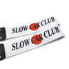 Two white silicone tow straps with black hardware featuring the text Slow Car Club and an orange circle logo