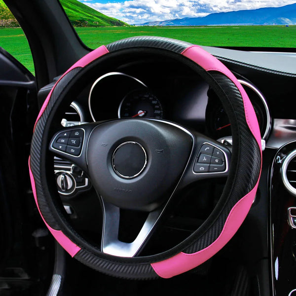 A close-up view of a black steering wheel with a pink PU carbon fiber cover inside a car interior.