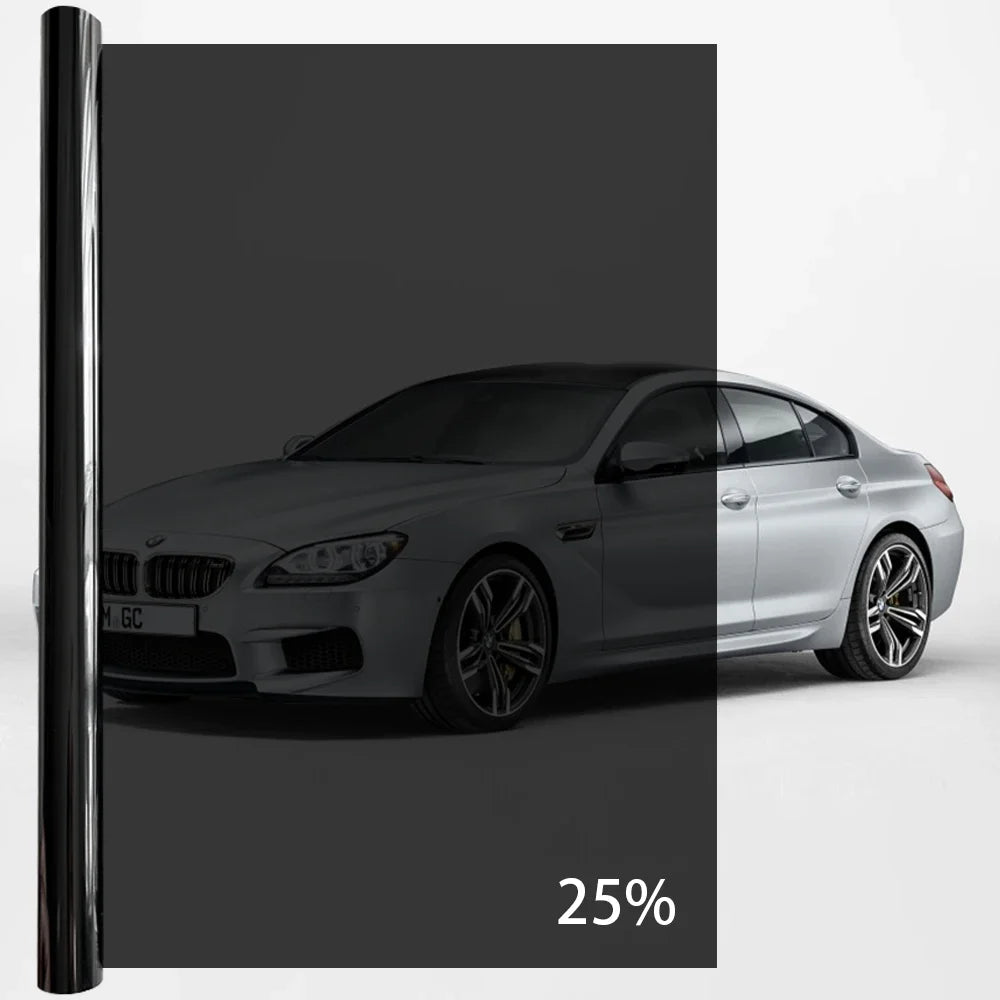 A silver BMW sedan with a black window privacy film applied, shown in a studio setting.