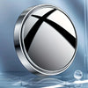 A round, silver mirror with a black cross design shown against a blue background.