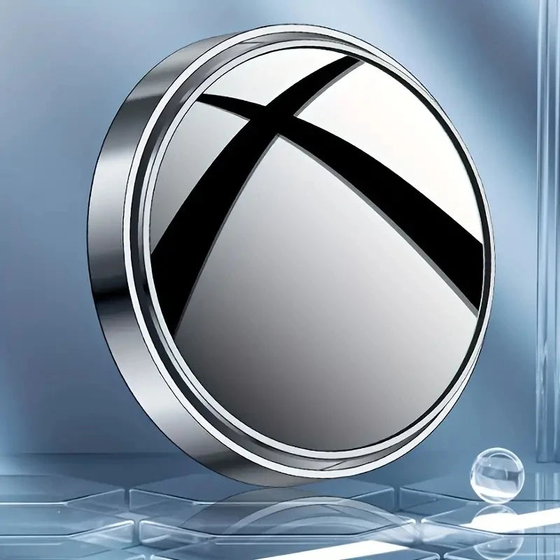 A round, silver mirror with a black cross design shown against a blue background.