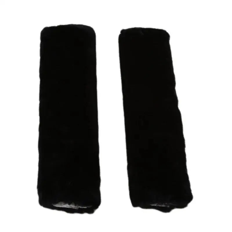 A pair of black luxury car seatbelt shoulder pads.