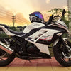 A white and black motorcycle with a clear visor is parked outdoors against a sunset backdrop.