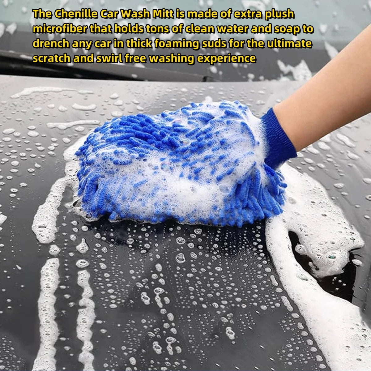 A hand wearing a blue microfiber car wash mitt is washing a car surface covered in water and soap foam.