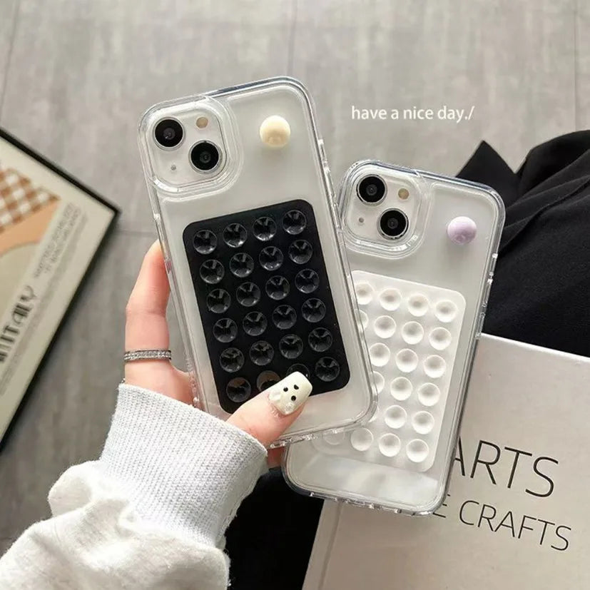 Support de téléphone en silicone clair avec plusieurs trous et rivets décoratifs tenu par une main.