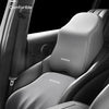 Gray ergonomic lumbar and neck support cushion installed in a car seat, demonstrating it can be leaned back or sideways.