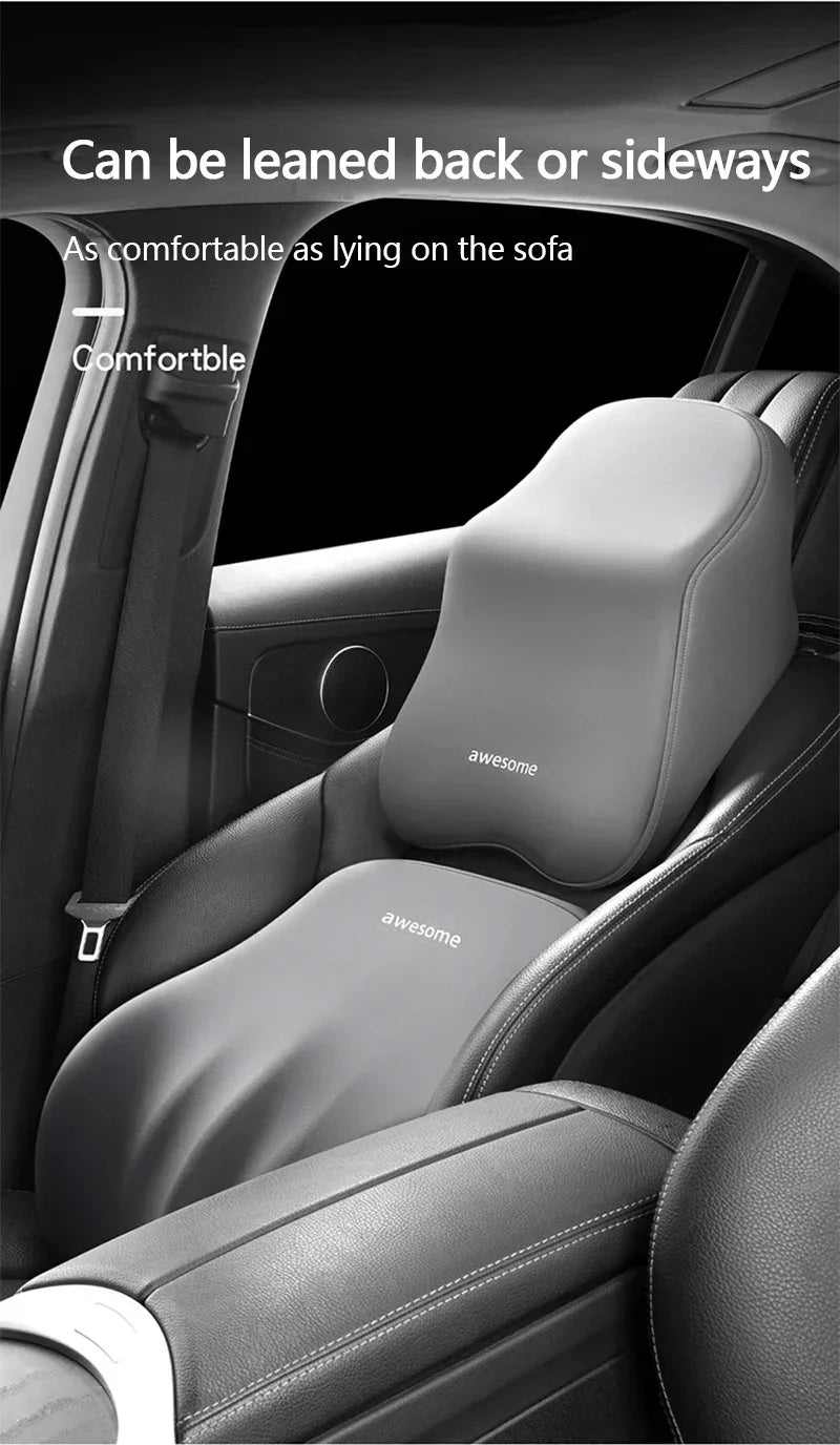 Gray ergonomic lumbar and neck support cushion installed in a car seat, demonstrating it can be leaned back or sideways.