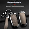 A close-up of a zinc alloy key sleeve and fob cover for a Mustang vehicle, showing the leather pattern and metal construction