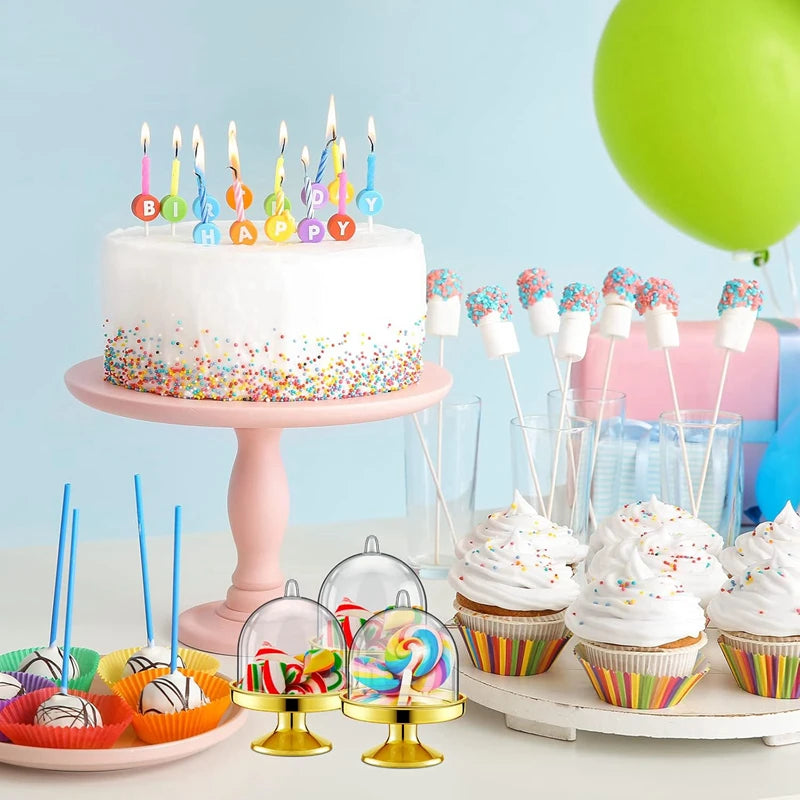 Präsentation von Mini-Candy-Cupcakes und Tortendekorationen auf einem rosa Ständer.