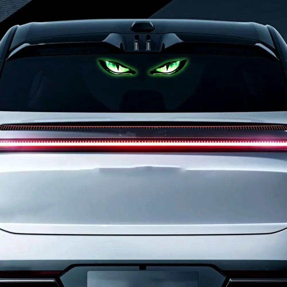 Close-up of a car's front grille with glowing green demon eye lights visible in the hood.