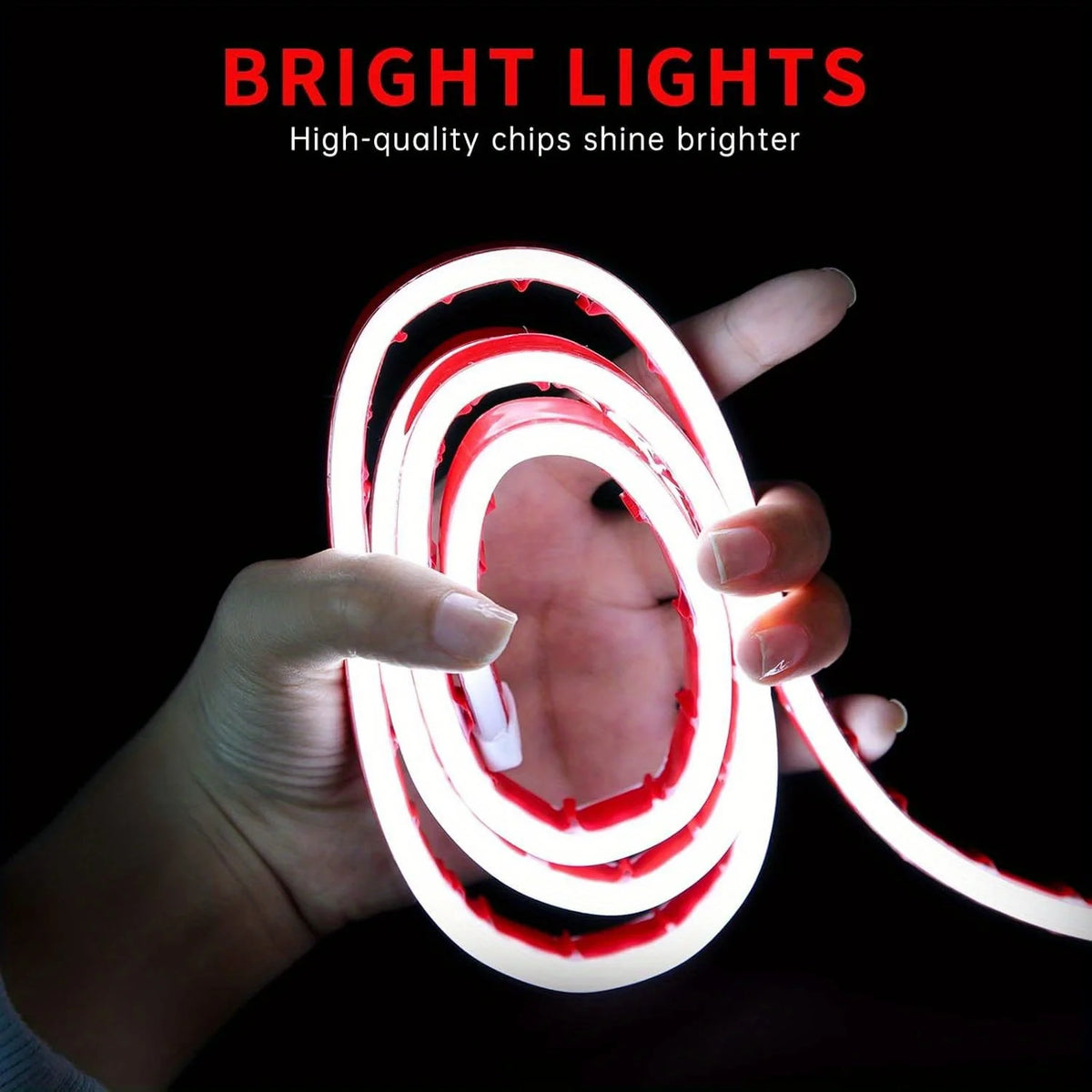Une main tient une bande lumineuse LED rouge et blanche en forme de anneau enroulé sur un fond sombre.