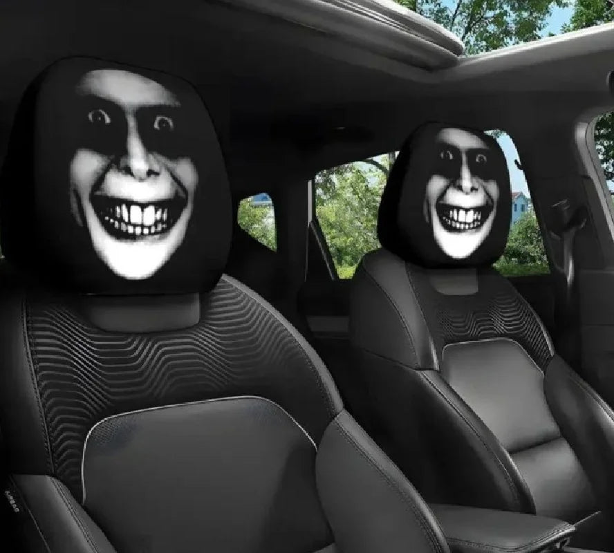 Two black car headrest covers shaped like horror faces are shown in a vehicle interior.