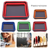A set of plastic and silicone parts trays in red, orange, and green colors shown next to a tool.
